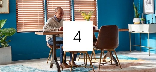 Man sitting at a table selecting new window treatments